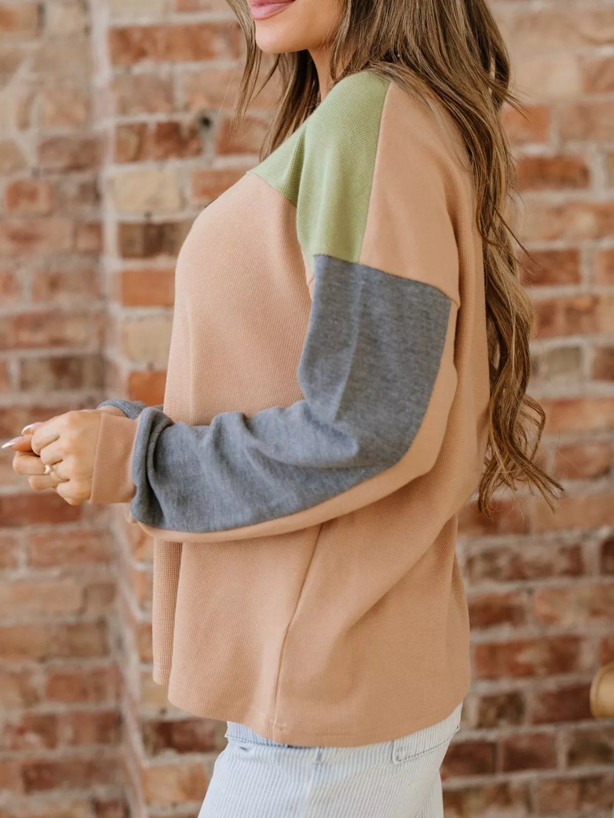 Side view of color block thermal henley top in camel with green and gray sleeves