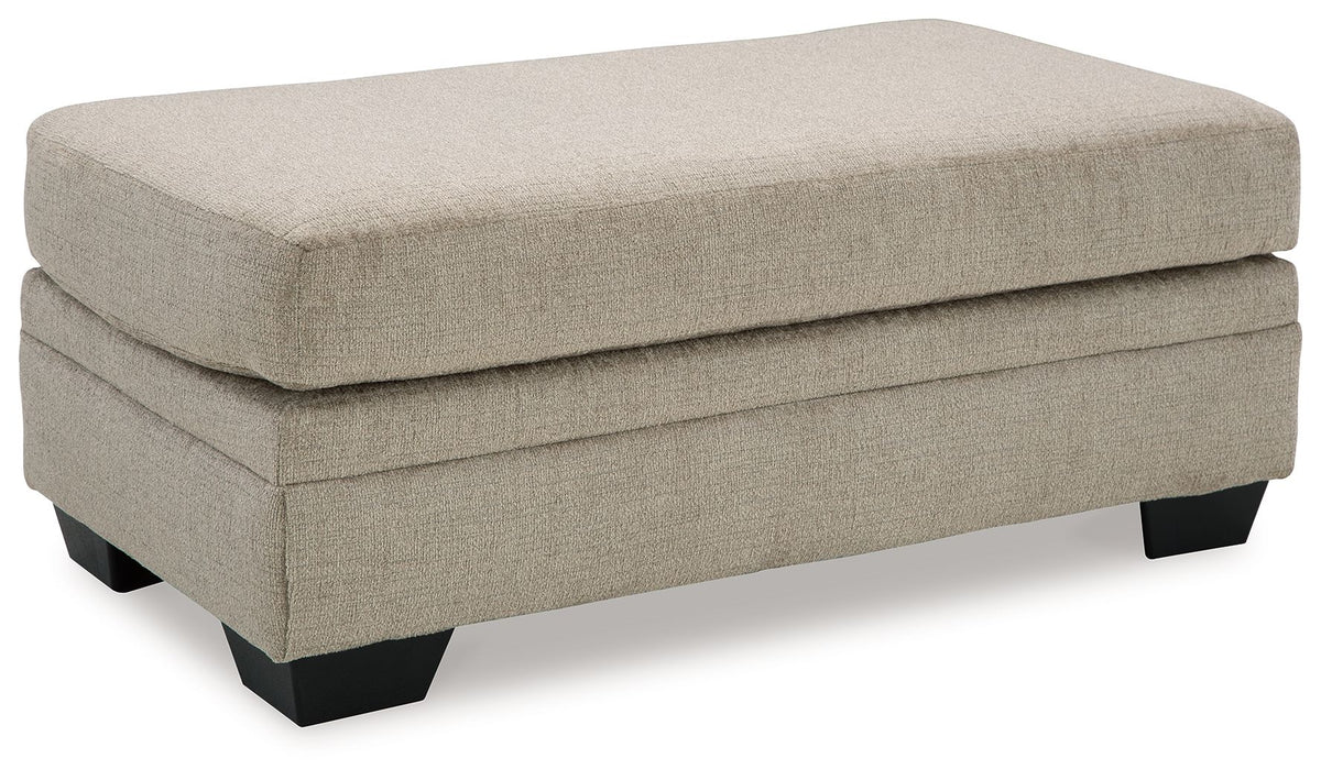 Upholstered ottoman in light beige fabric with black block legs