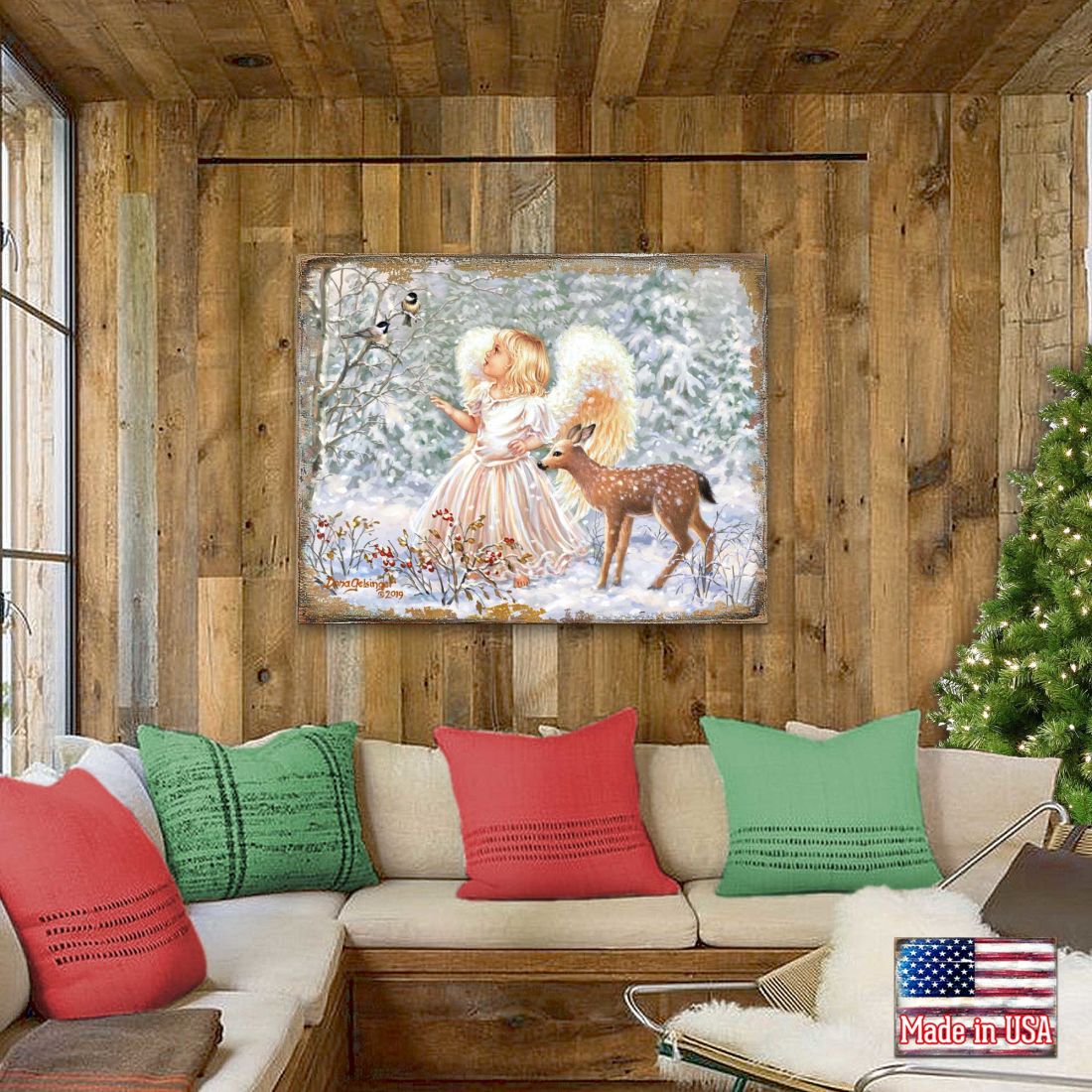 Framed wooden wall art above sofa featuring angel girl and deer in snowy winter scene