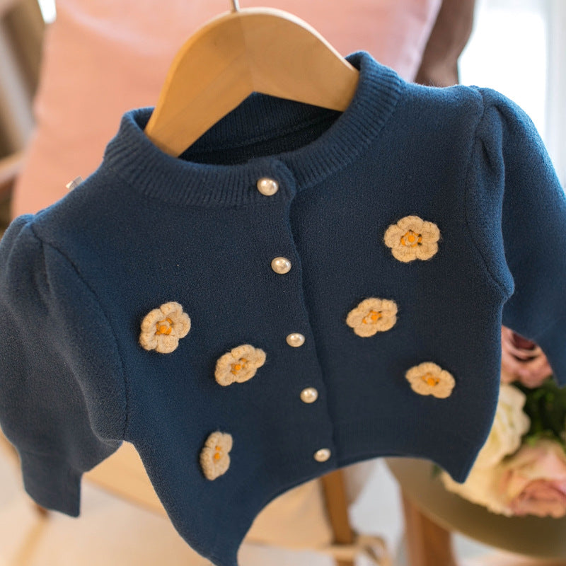 Blue kids cardigan sweater close-up with embroidered flower details and button placket