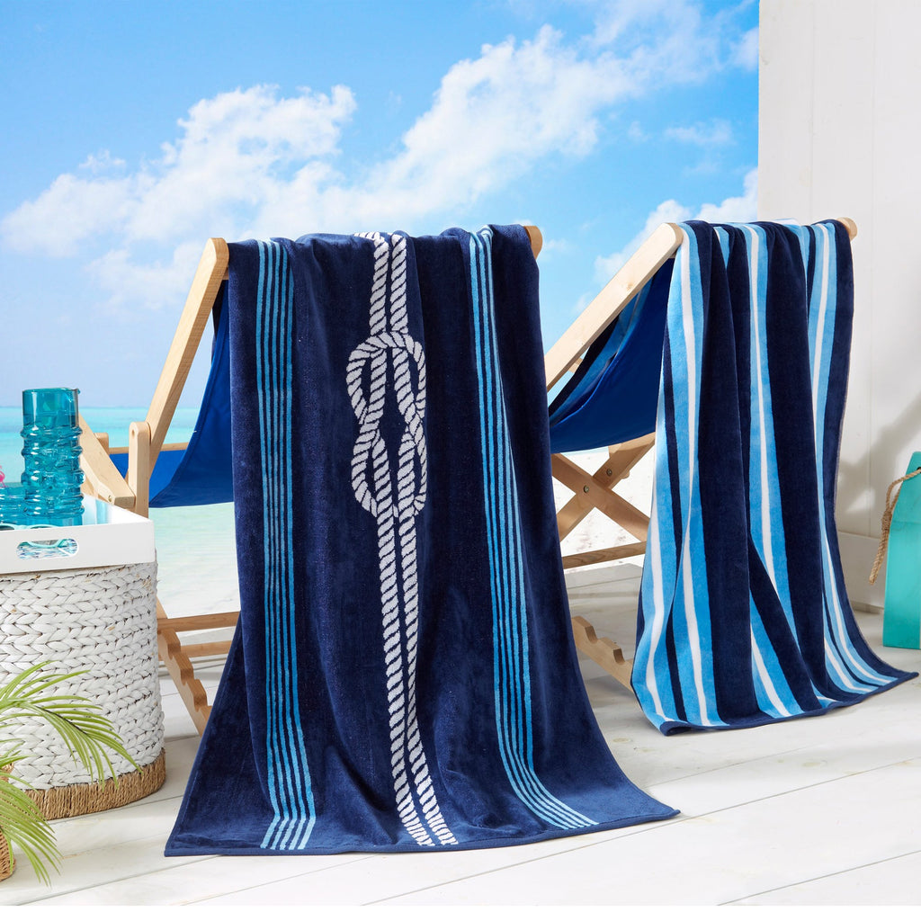 Cotton velour beach towel draped on chair with navy and light blue stripe pattern