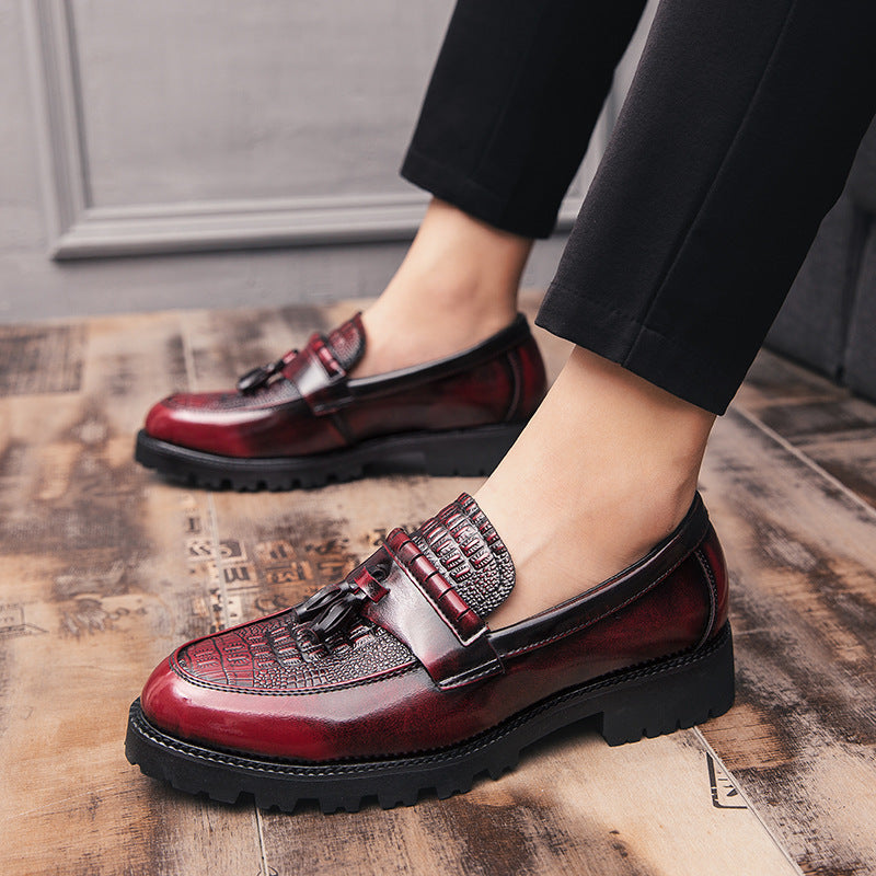 Men's leather loafers with tassel detail, red with patterned strap, worn with dark pants