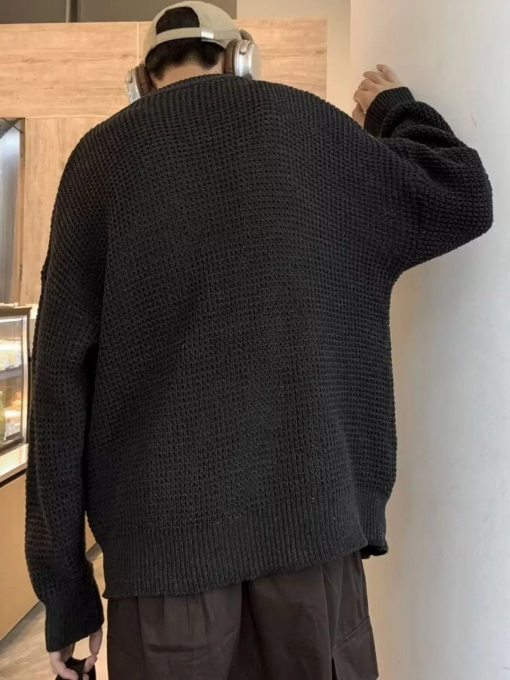 Black waffle-knit crewneck sweater, back view with ribbed hem and long sleeves