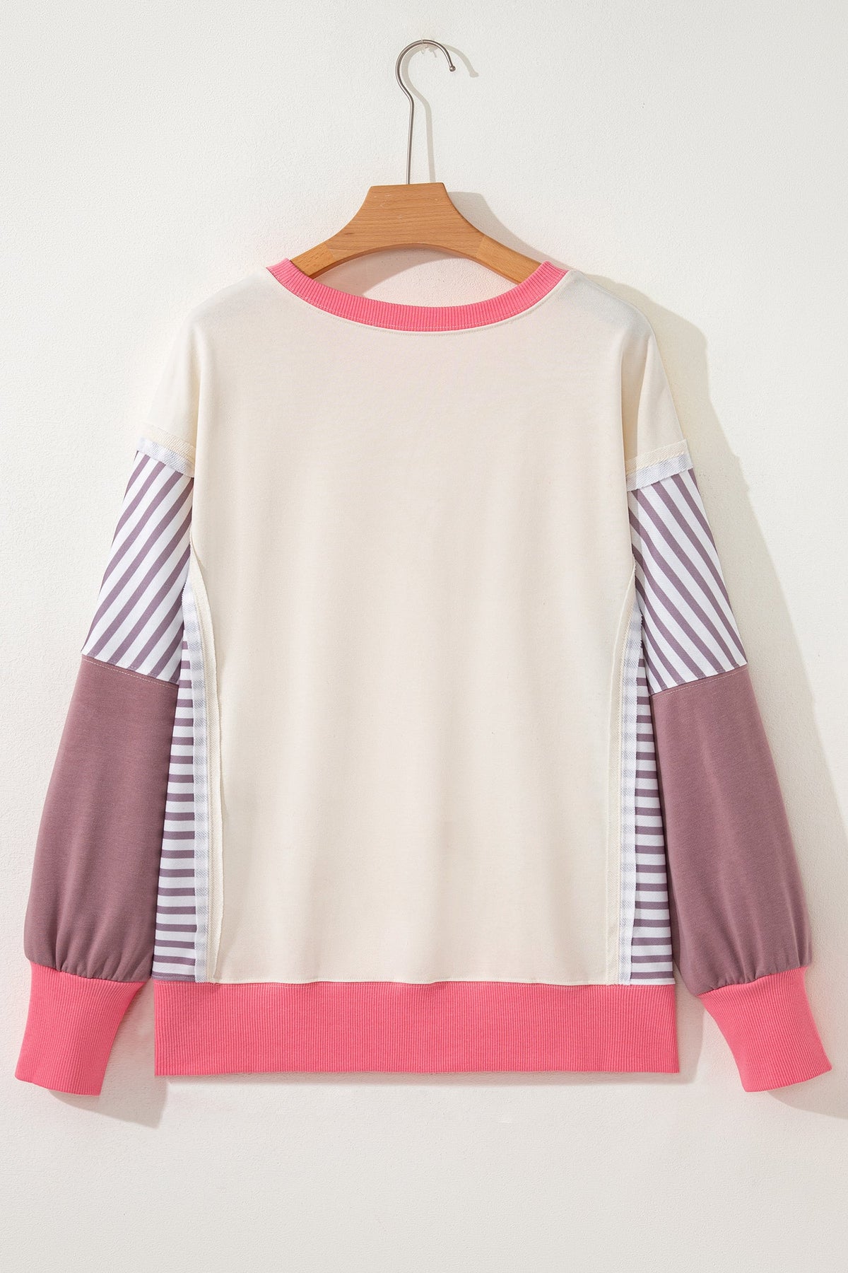 Back dolman sweatshirt with cream body, purple striped sleeves, and pink hem