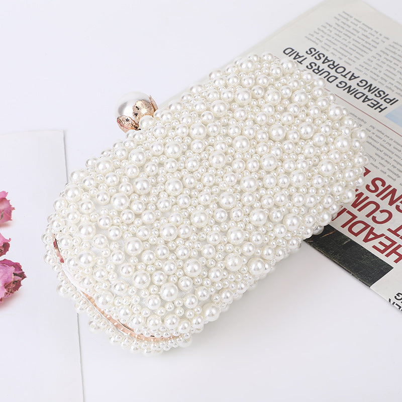 White pearl beaded clutch with gold-tone clasp detail, angled view