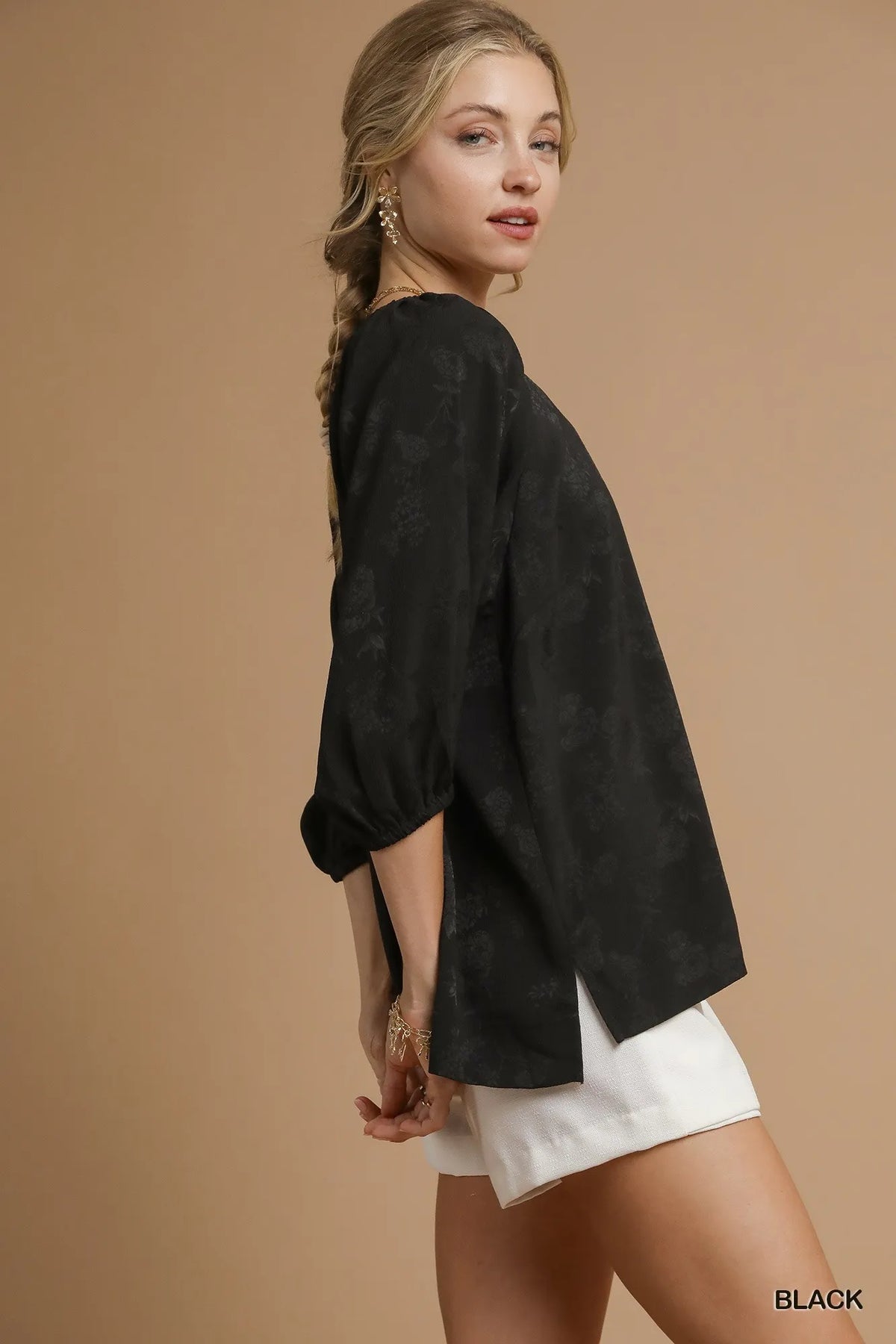 Black jacquard blouse with elbow-length puff sleeves and curved hem