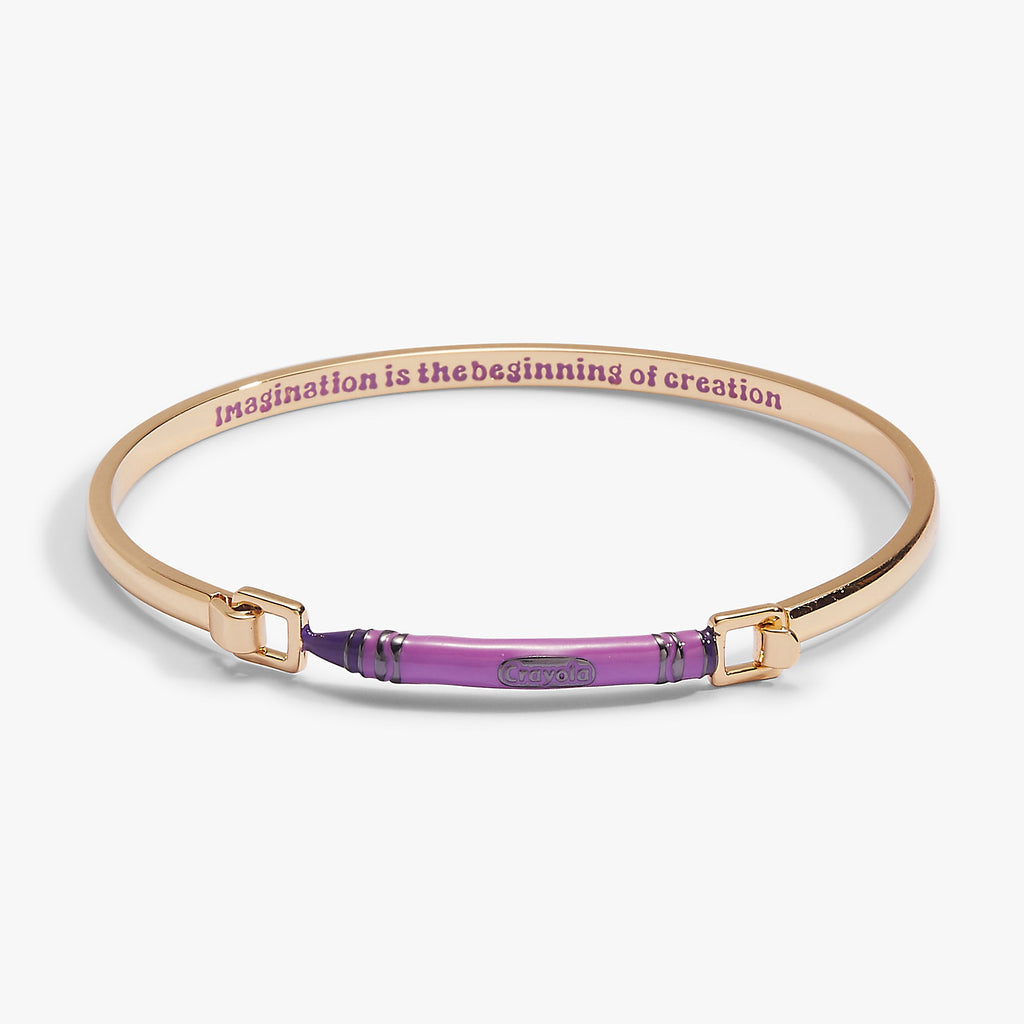 Gold-tone tension bangle with purple crayon-style center and engraved text on band