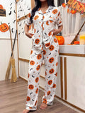 White pajama set with pumpkin, ghost, and bat prints, short-sleeve button-front top and pants