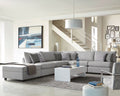 Grey modular sectional sofa with corner chaise, upholstered in light fabric