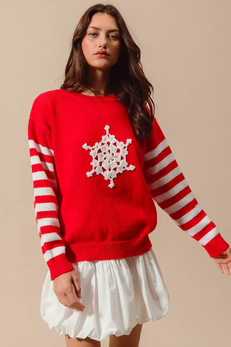Red knit sweater with white crochet snowflake applique and red-and-ivory striped sleeves