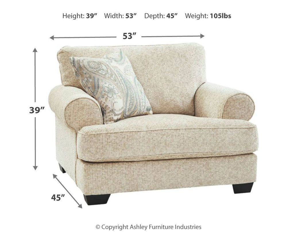 Sandstone upholstered chair with patterned pillow, rounded arms, and dark block feet