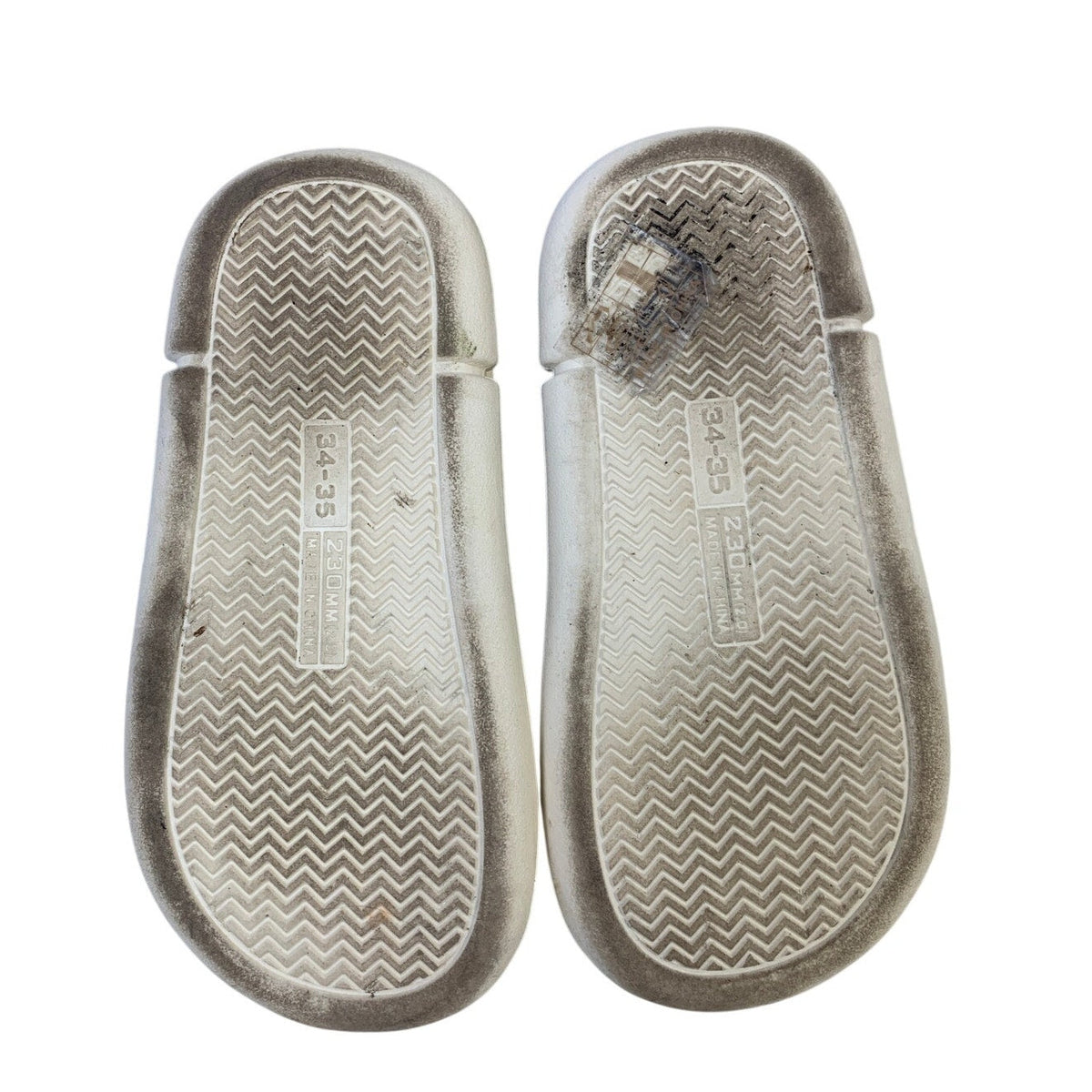Gray slip-on slippers showing textured zigzag outsole and cream sidewall
