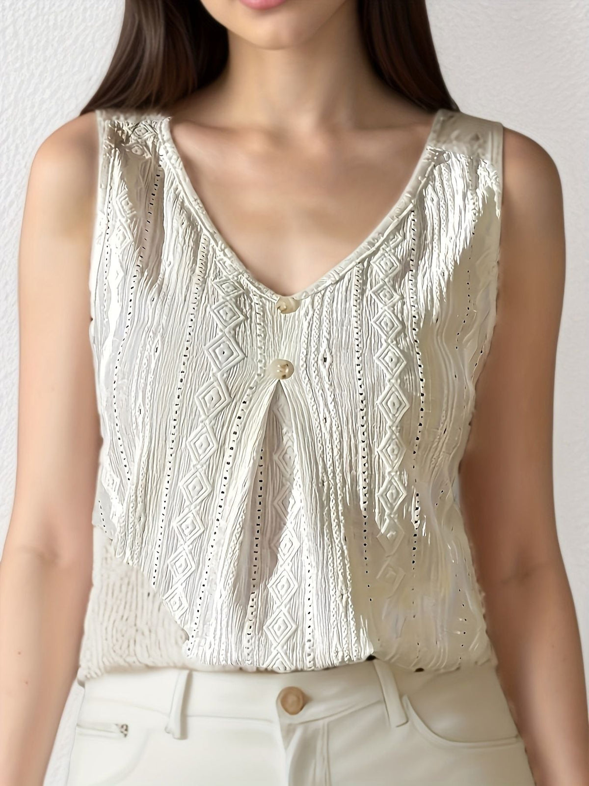 White sleeveless V-neck vest with textured embroidery and gold center button placket