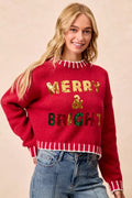Red sequin Christmas sweater with “Merry & Bright” lettering and striped knit trim