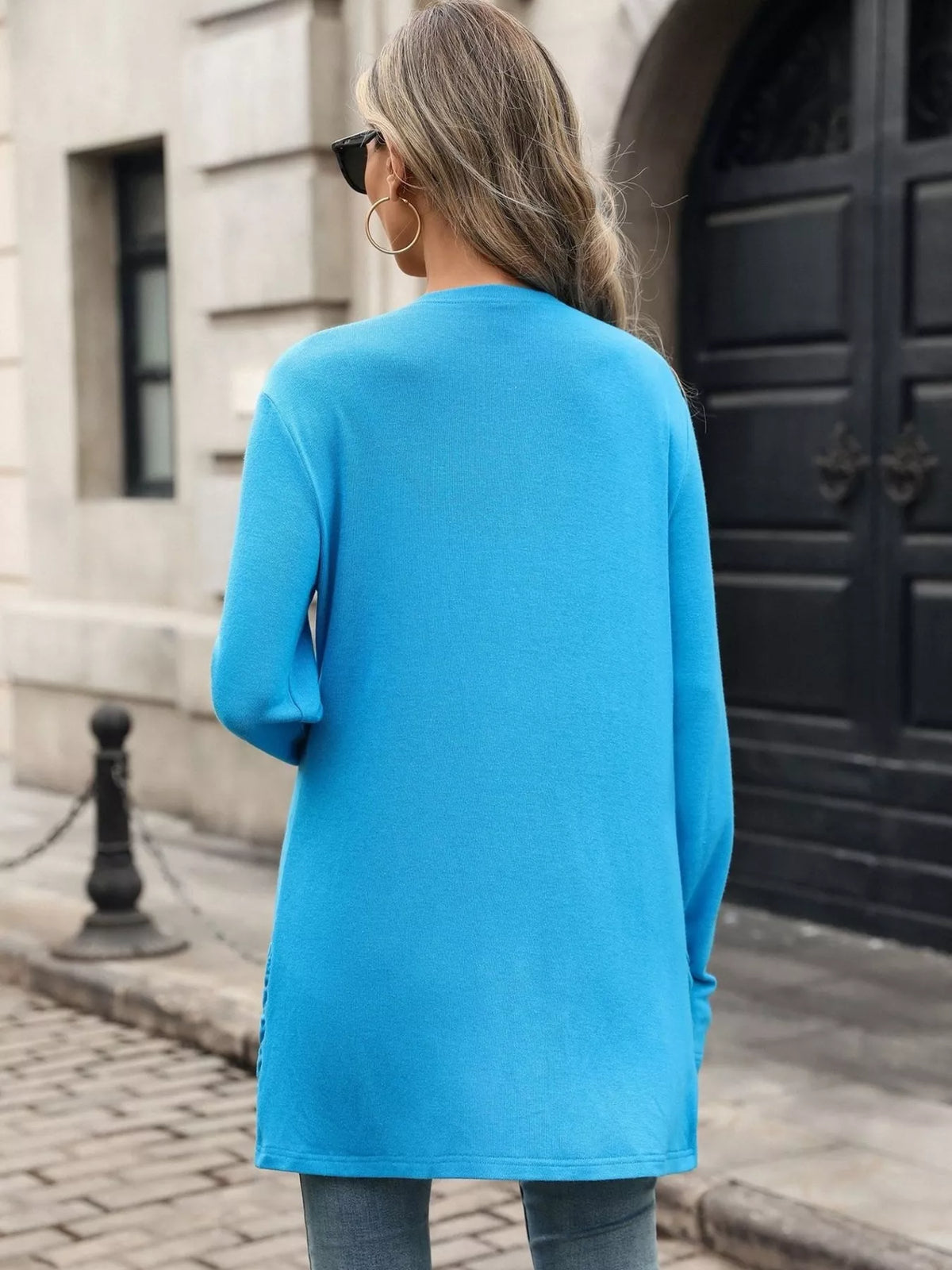 Blue open-front cardigan with long sleeves, back view.