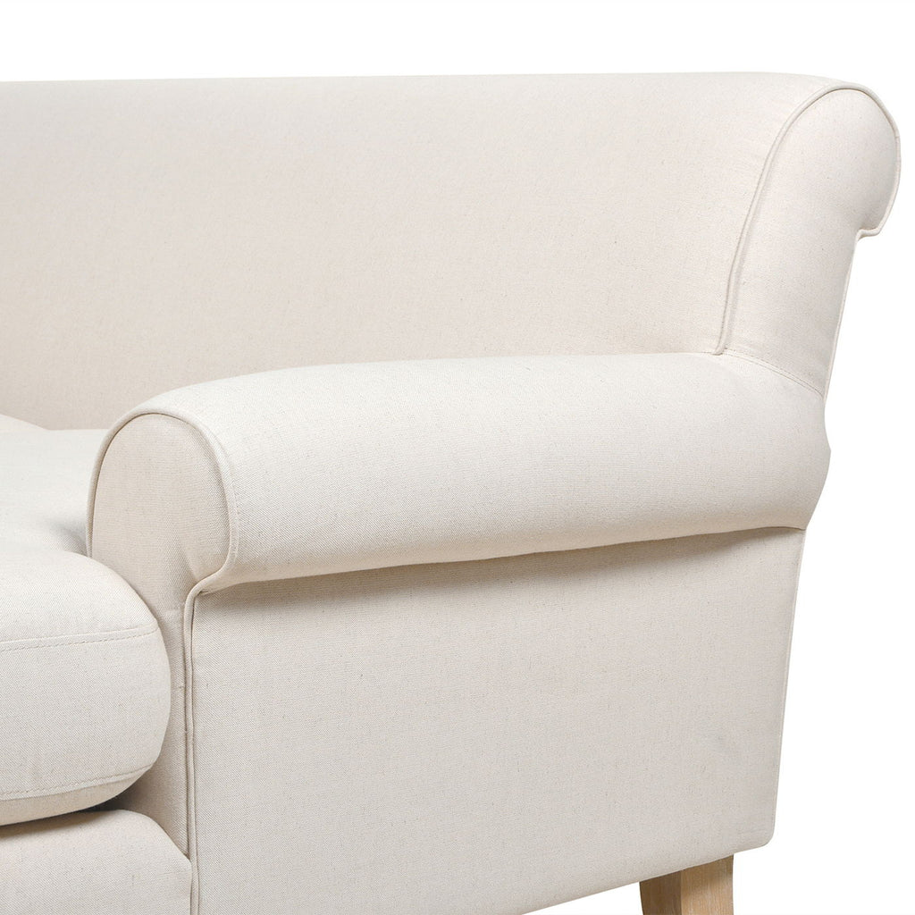 Light beige upholstered sofa arm with rounded armrest and neat stitched seams