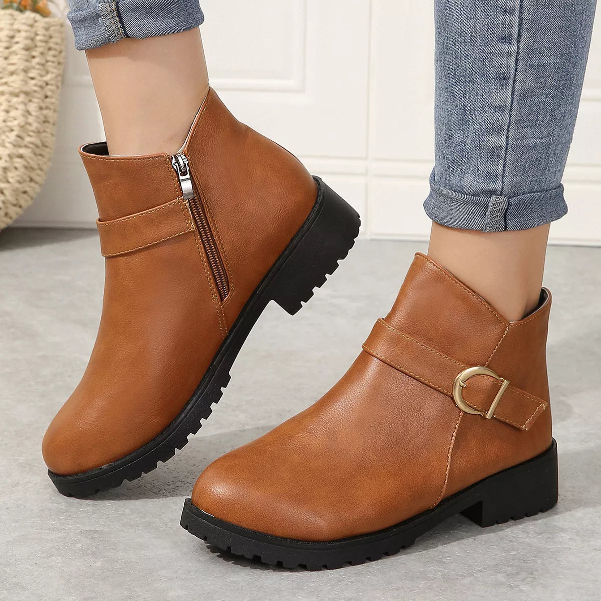 Caramel ankle boots with gold buckle strap and side zipper, chunky tread sole.