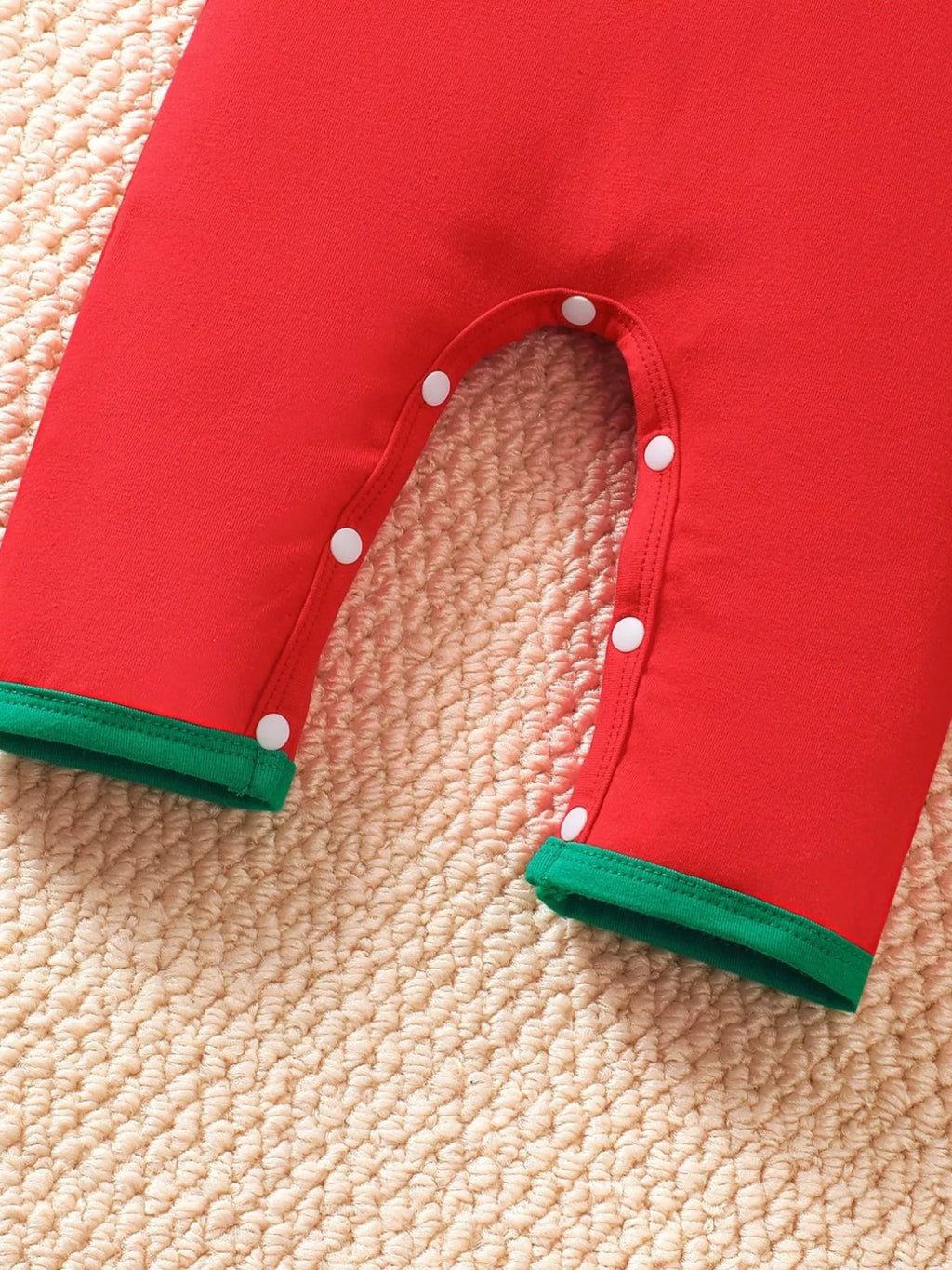 Red kids Christmas jumpsuit with snap-button legs and green cuff trim