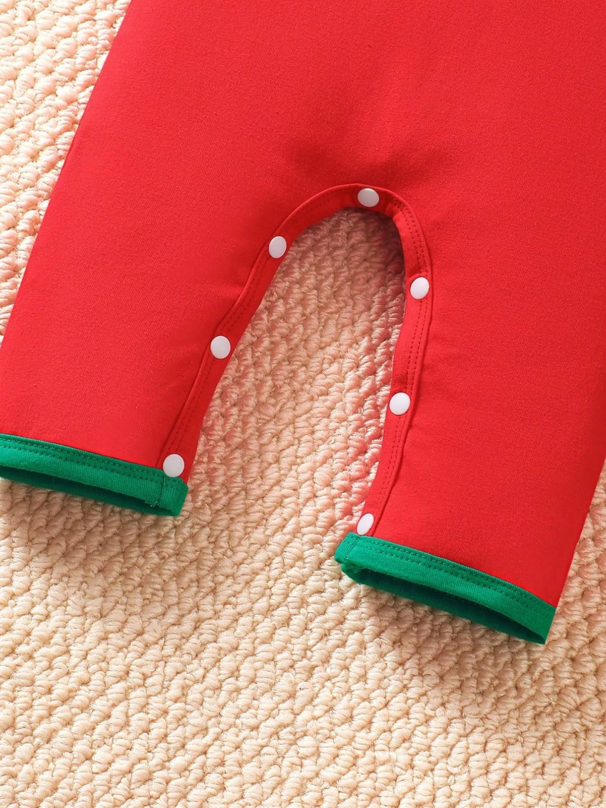 Red kids Christmas jumpsuit with snap-button legs and green cuff trim