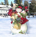 Christmas yard decoration sign with smiling snowman holding gift, red hat and wreath accents
