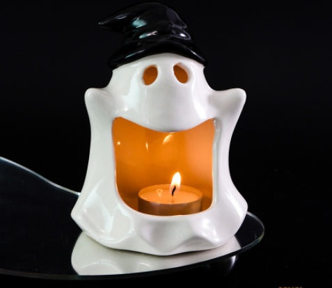 Ceramic witch-ghost candle ornament with lit tea light, white body and black hat