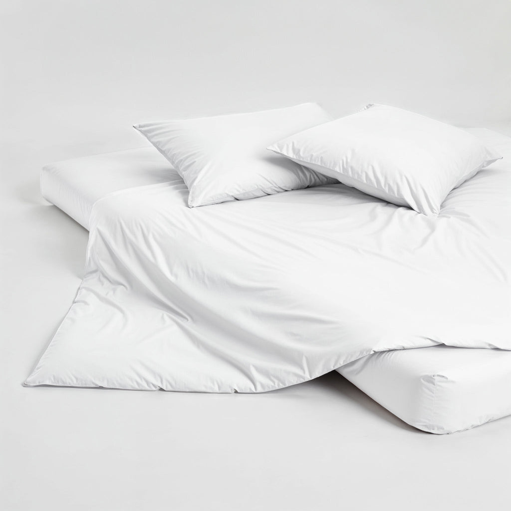 White sateen duvet cover folded with matching pillows, smooth wrinkle-free surface