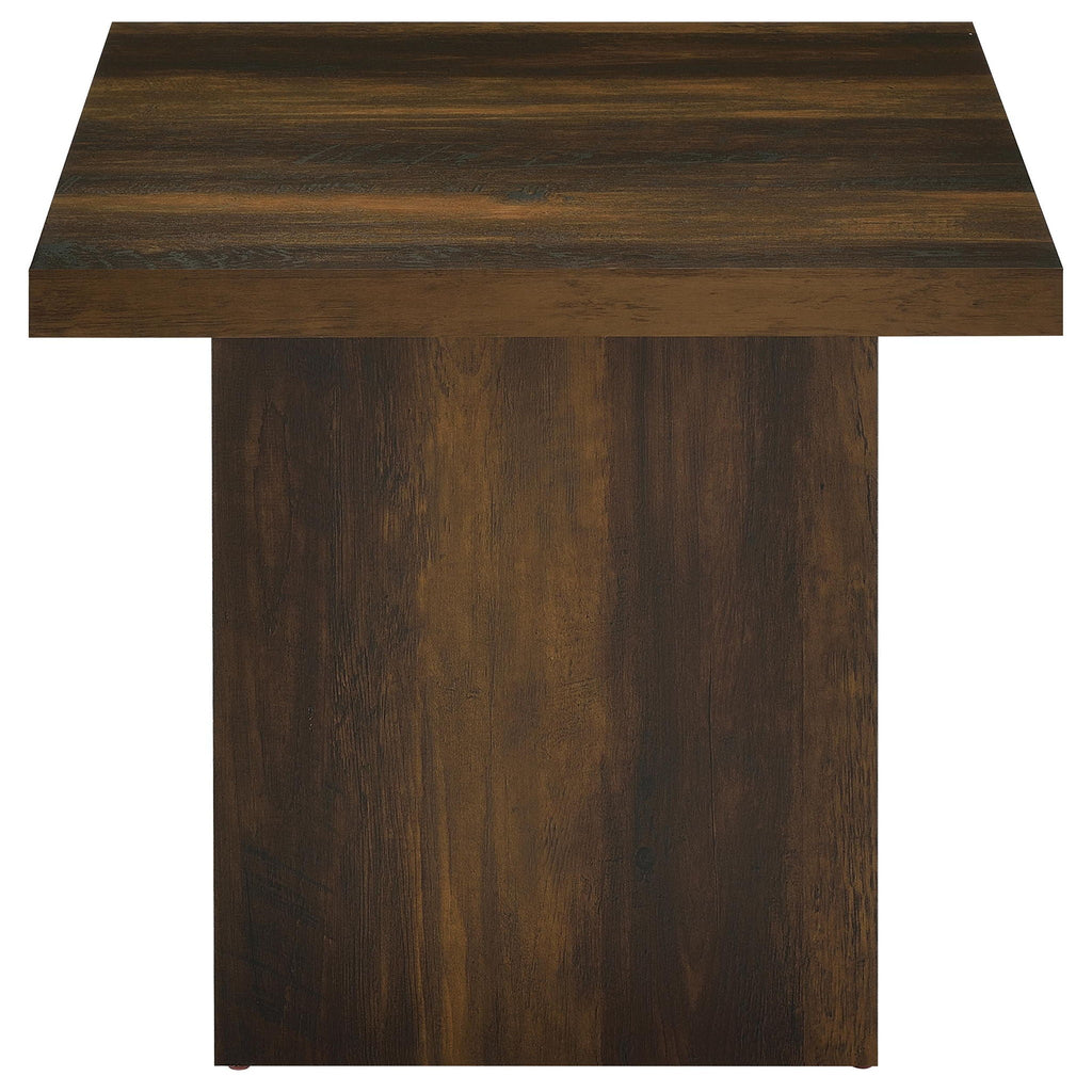 Square coffee table with dark pine finish, flat top and paneled legs, front view.