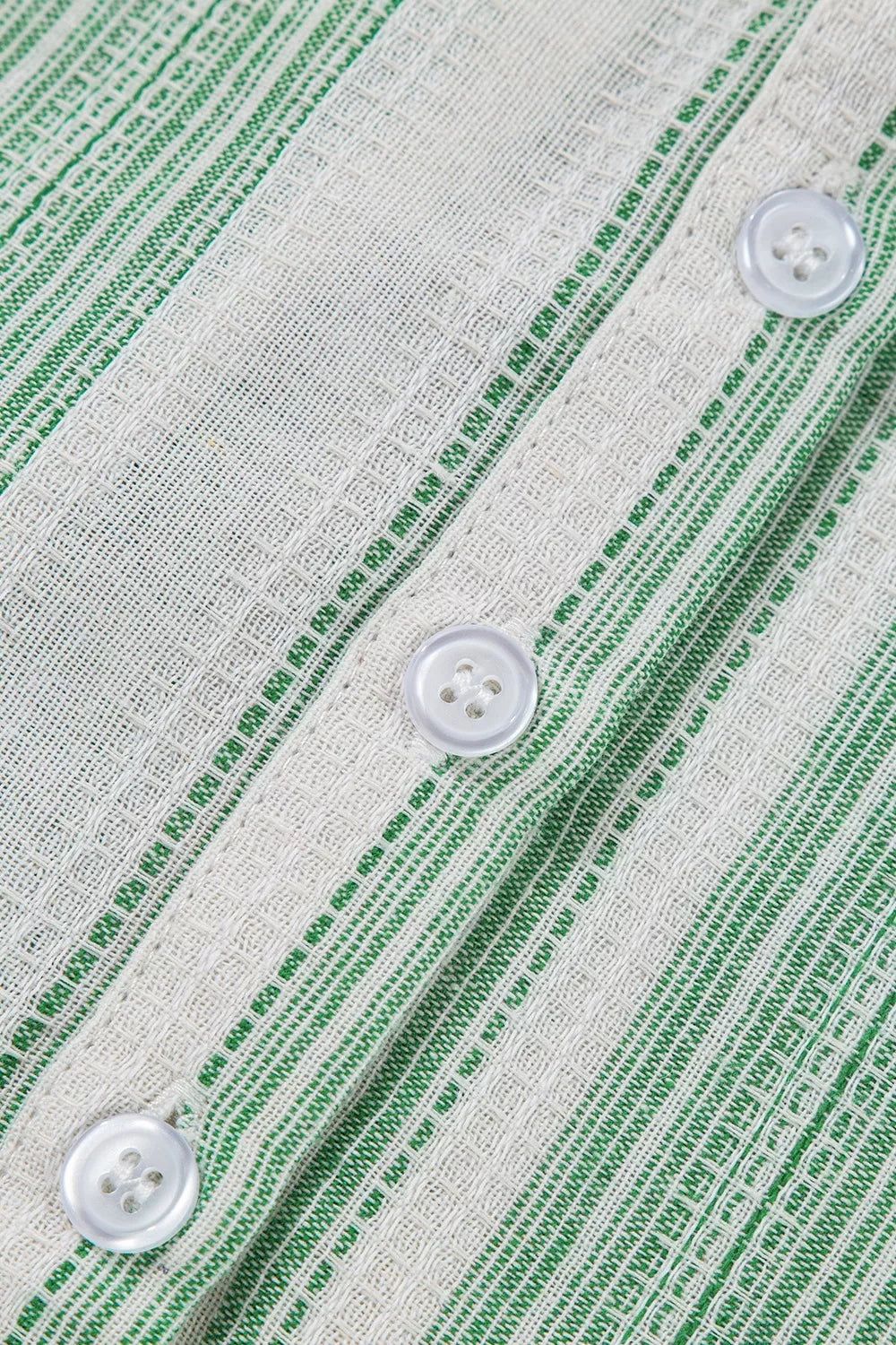 Light green striped gauze blouse fabric close-up with white buttons