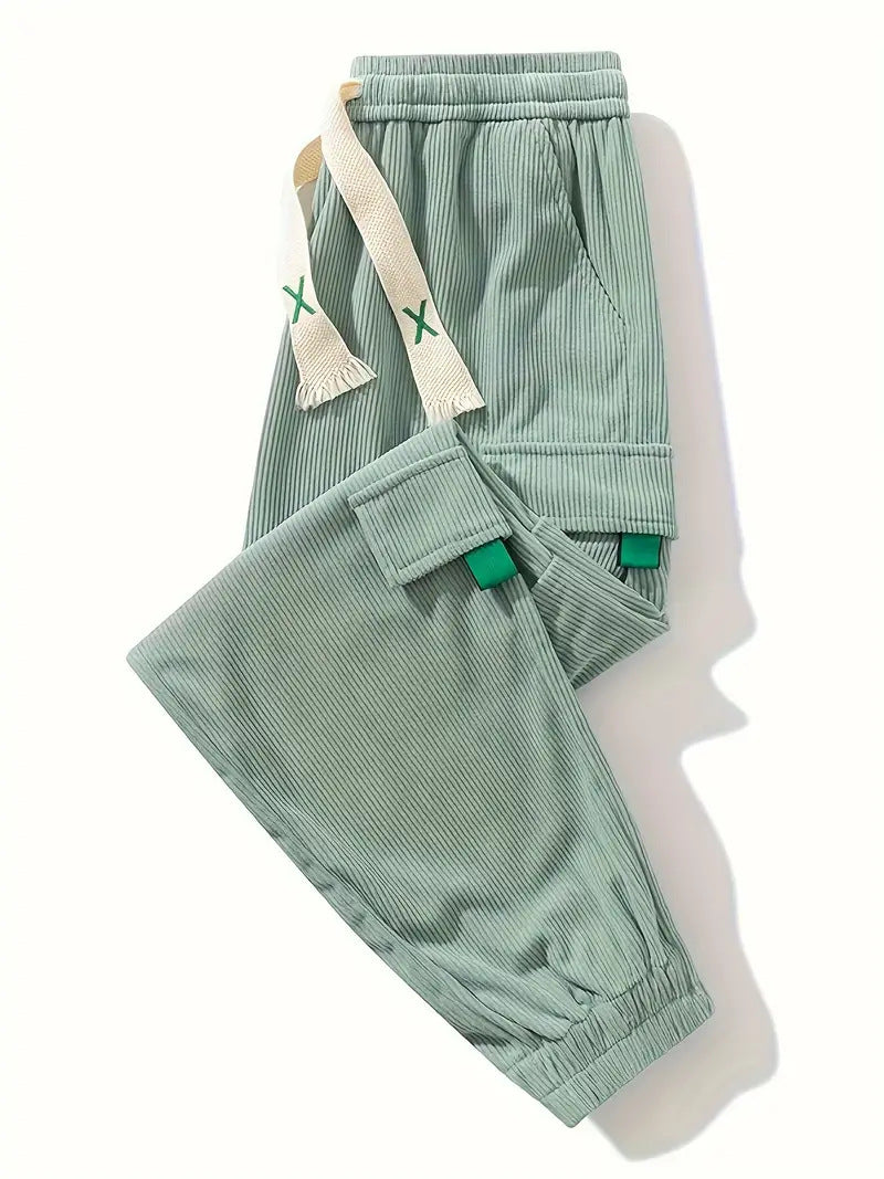 Light green corduroy pants, folded view, with cargo pockets and drawstring ties