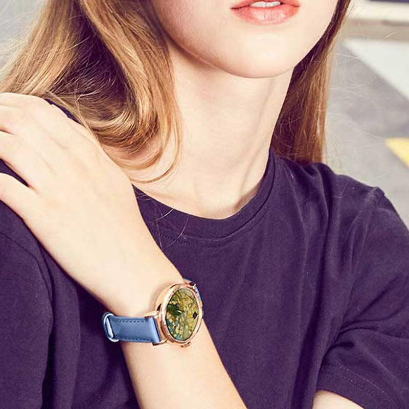 Quartz wristwatch with blue strap and rose-gold case, round colorful art dial