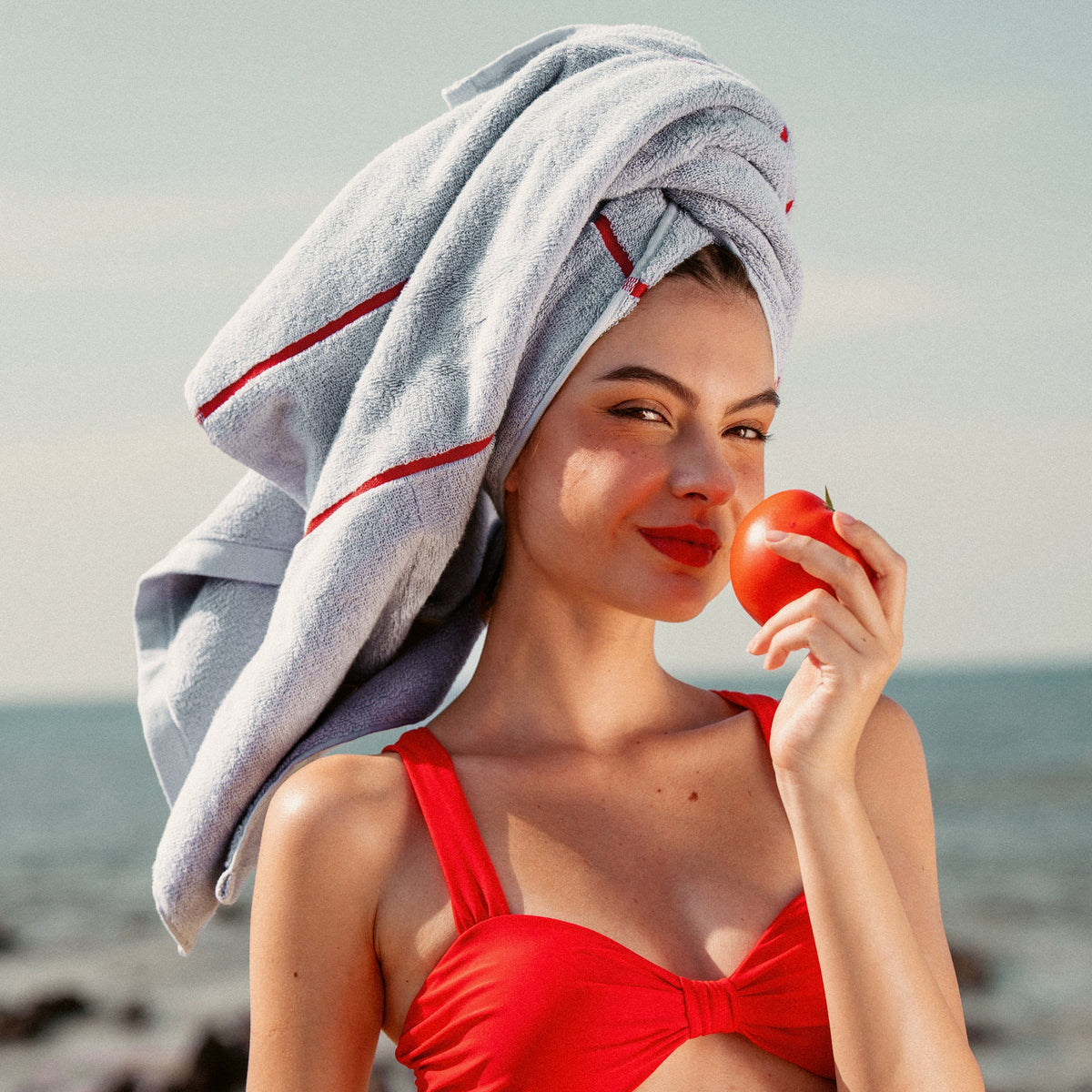 Light blue cotton towel with red stripe, used as a hair towel
