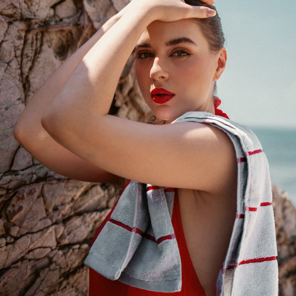 Light gray towel with red stripe borders, draped across the shoulder