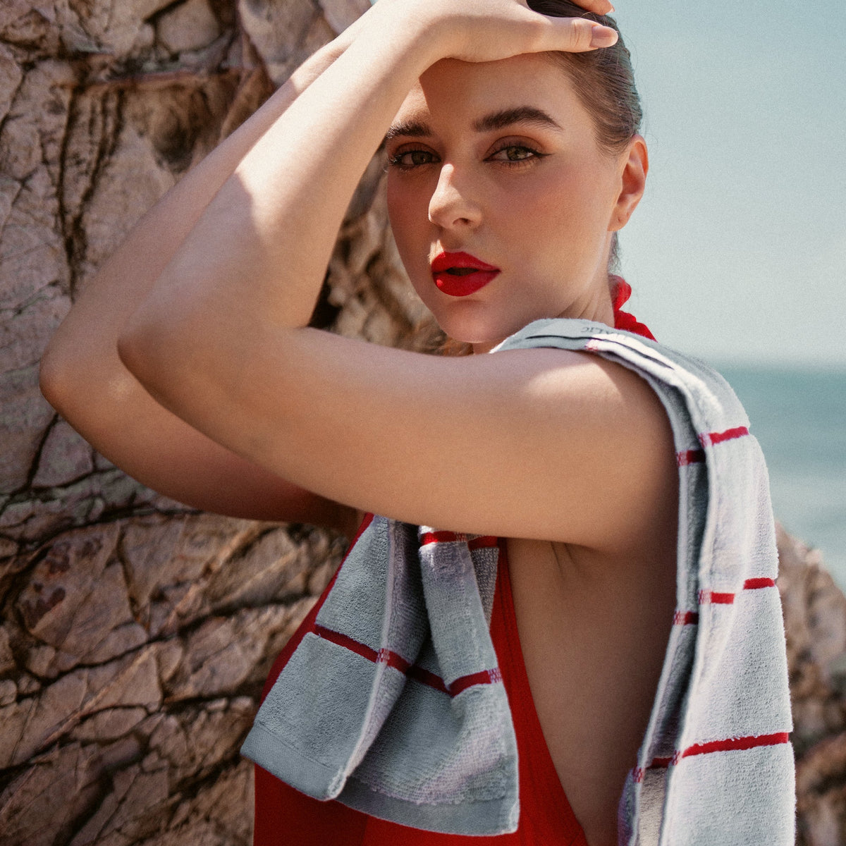Light gray towel with red stripe borders, draped across the shoulder