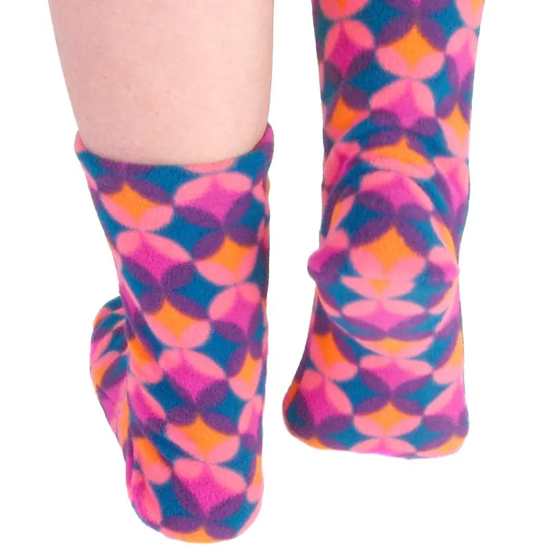 Close-up of pink, blue, and orange patterned socks on legs