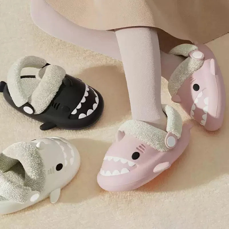 Kids shark slippers with plush lining in black and pink, worn by a child
