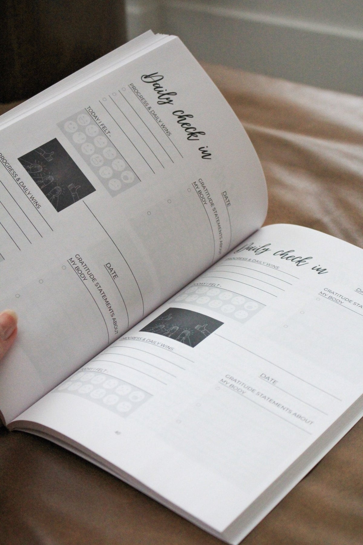 Detox book open to tracking worksheets with checkboxes and small photo boxes
