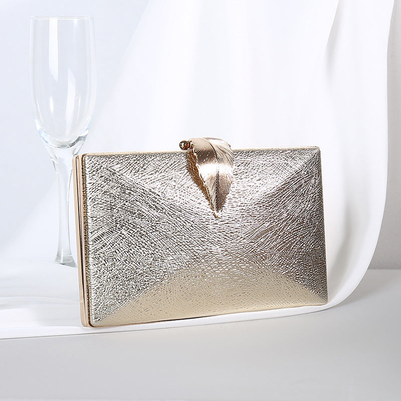 Gold textured small evening crossbody bag with gold-tone bow clasp.