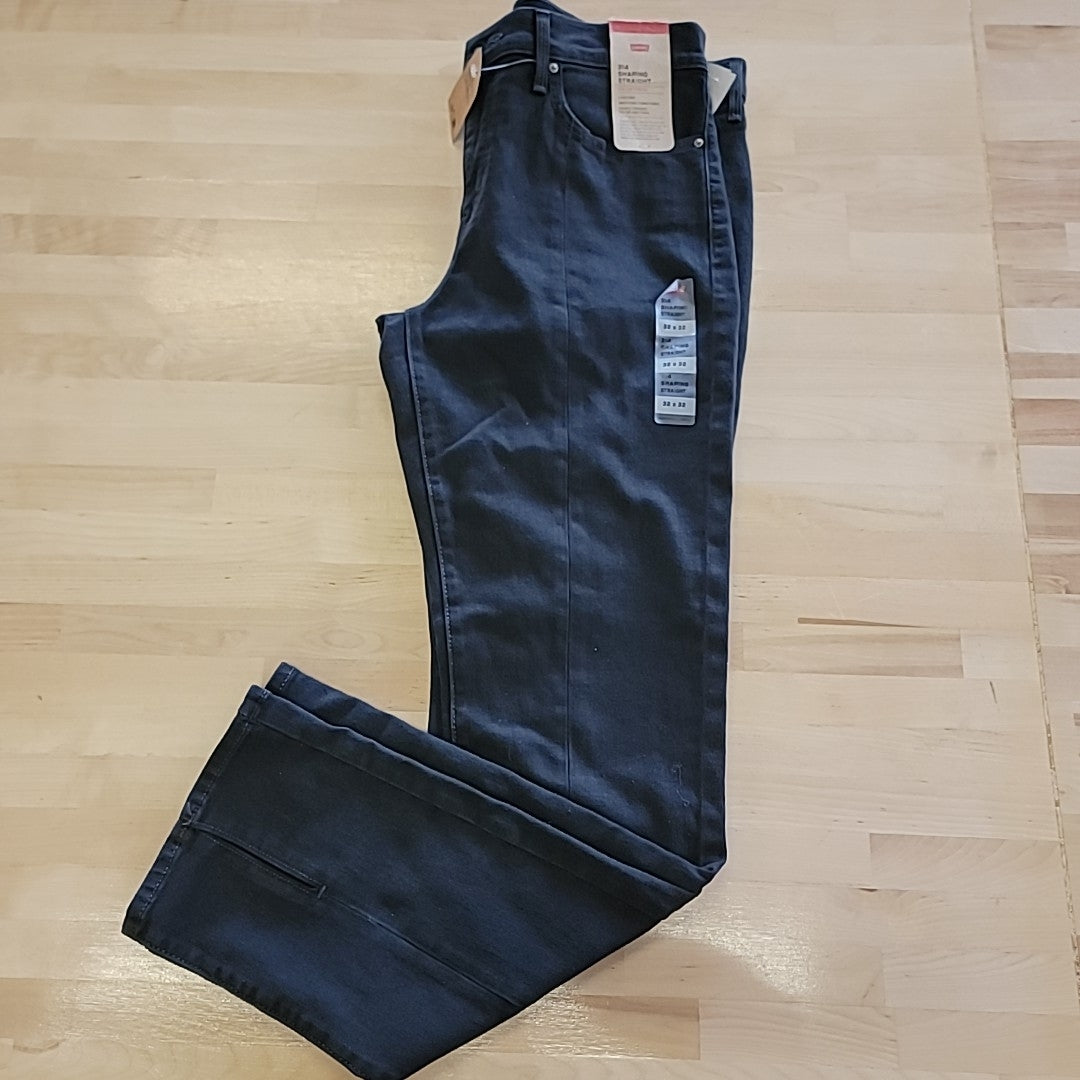 Dark blue straight-leg jeans laid flat, button fly and five pockets