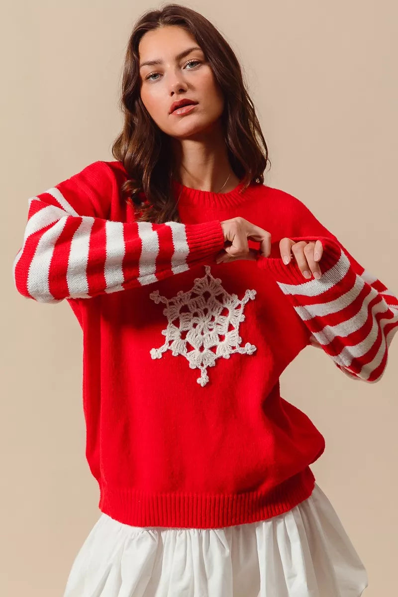 Red knit sweater with white crochet snowflake and wide red-and-ivory striped sleeves