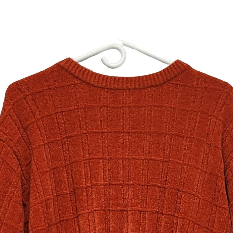 Orange textured grid knit sweater with ribbed crew neck and long sleeves