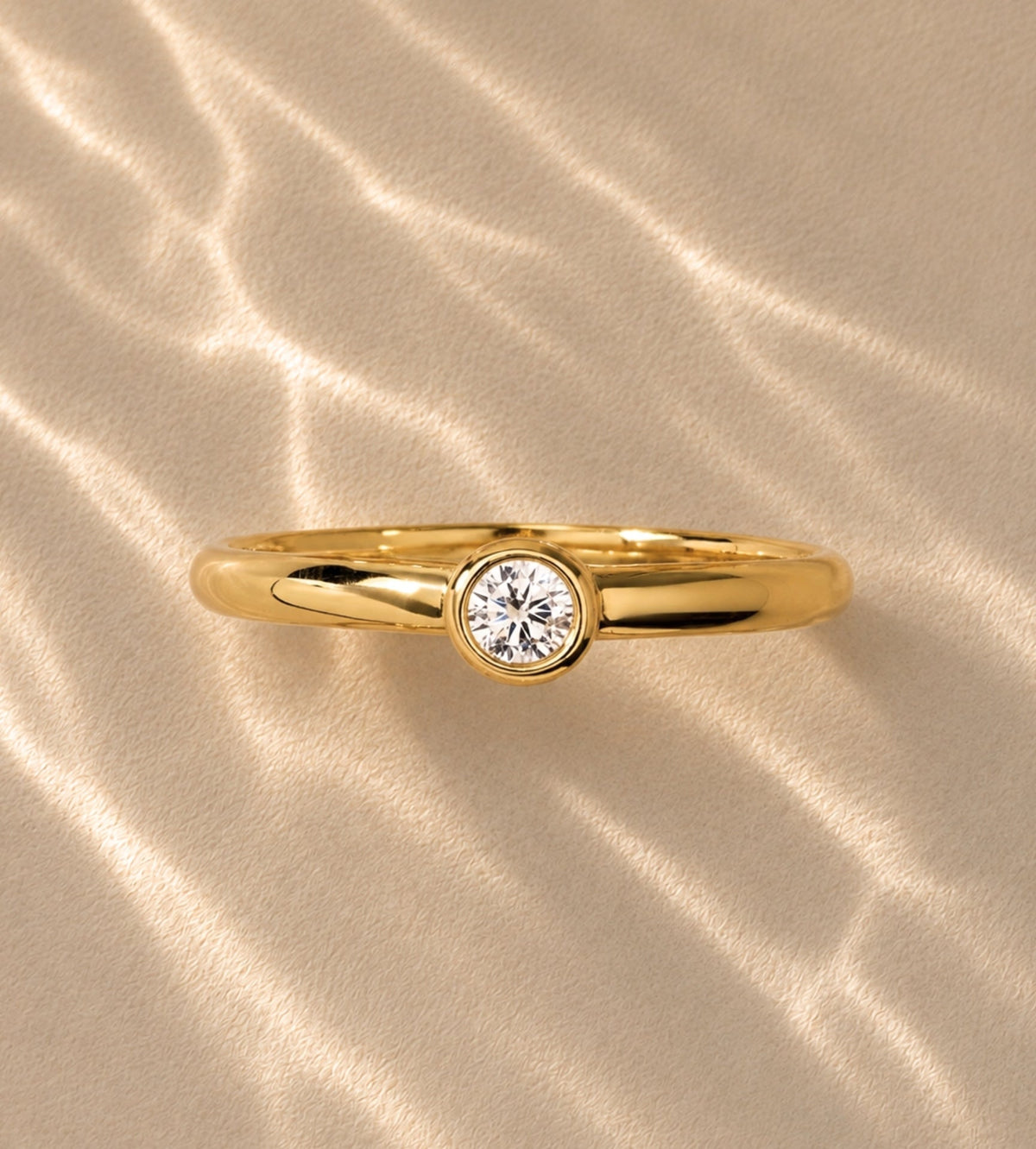 Gold-tone band with bezel-set round stone, close-up