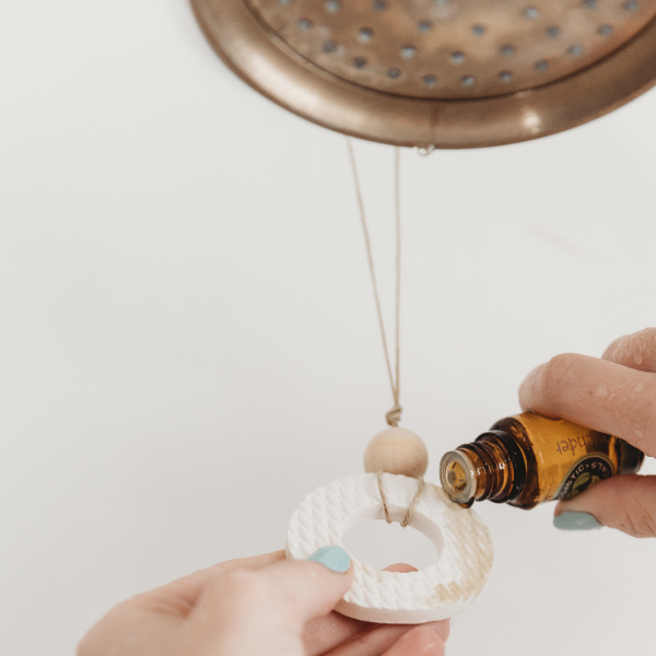Clay shower diffuser ring with essential oil bottle dripping onto it