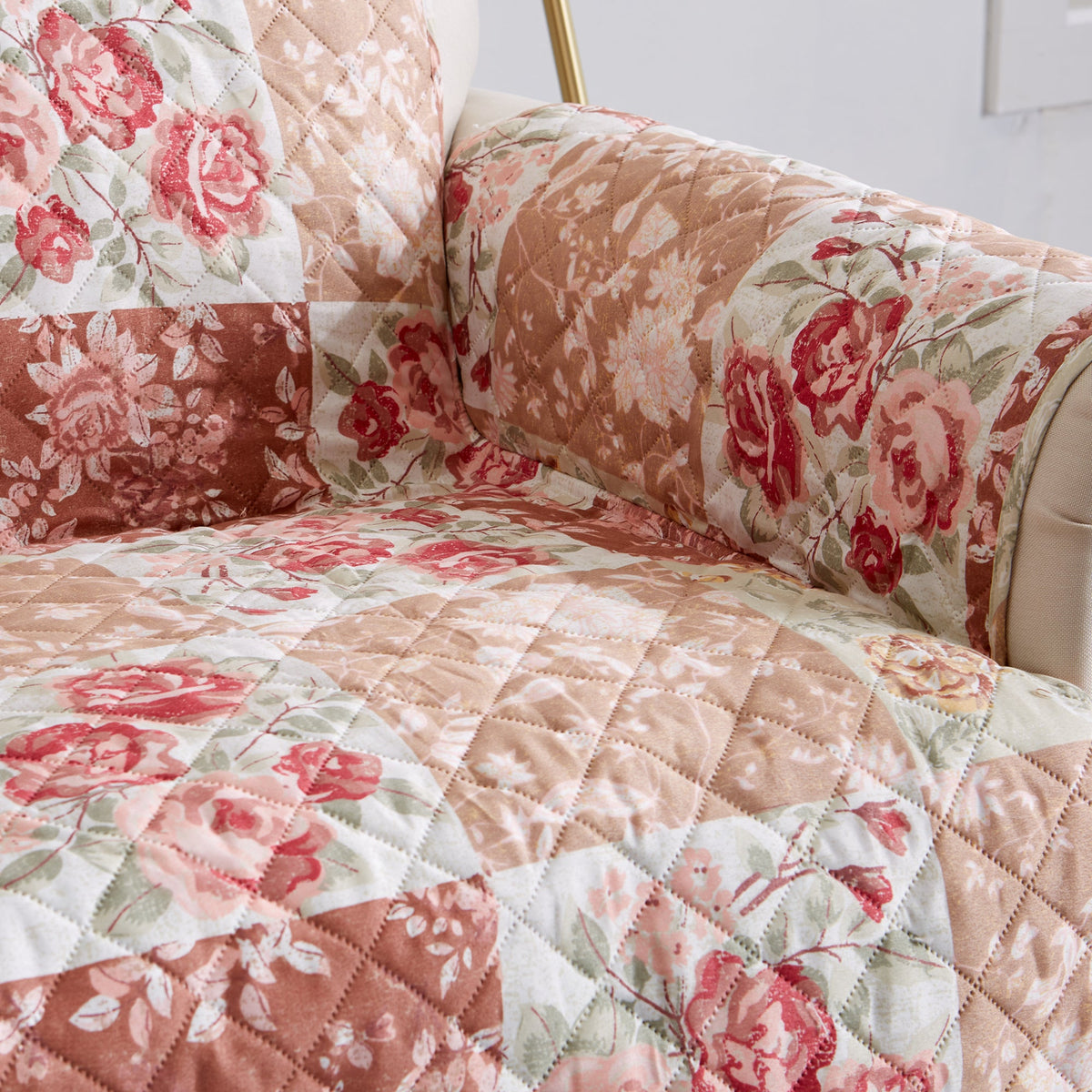 Close-up of quilted floral patchwork protector corner with red rose print on cream backing