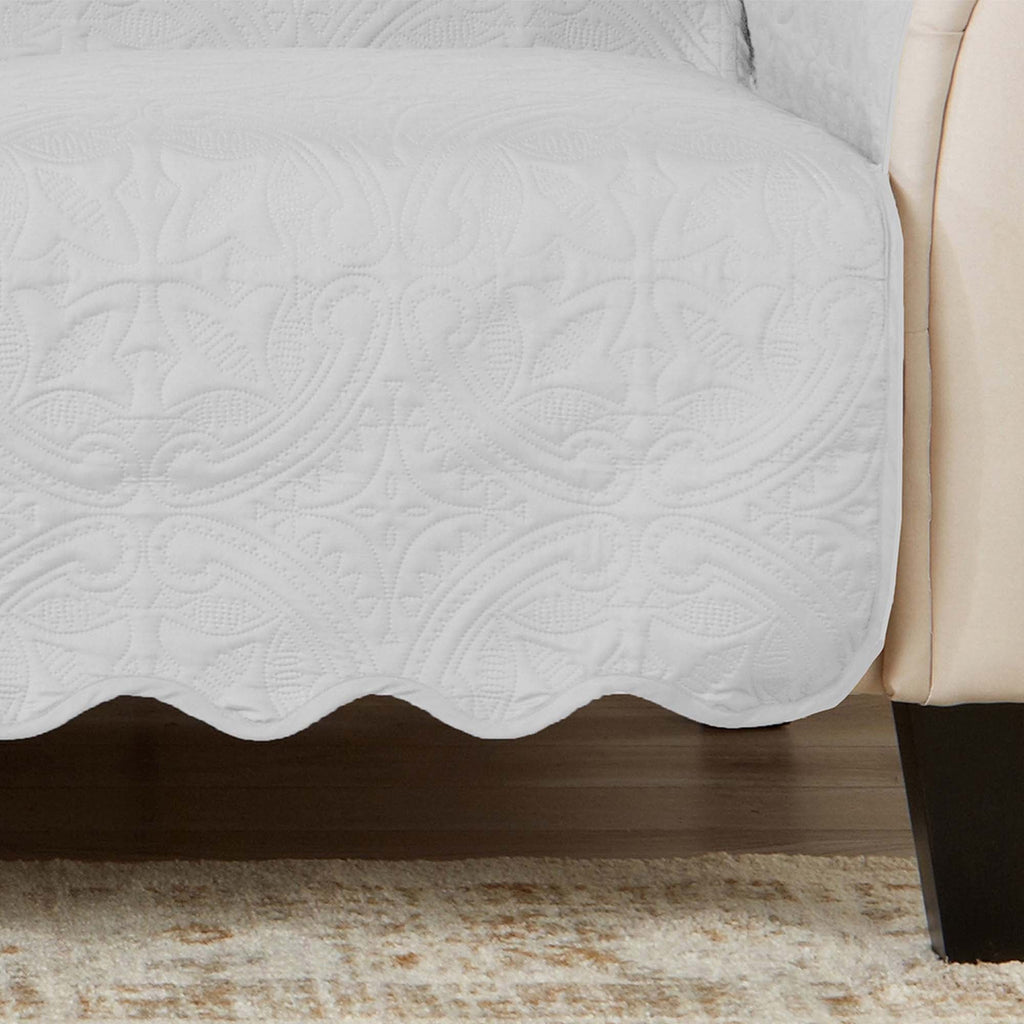 White loveseat protector with textured quilt pattern and scalloped bottom hem