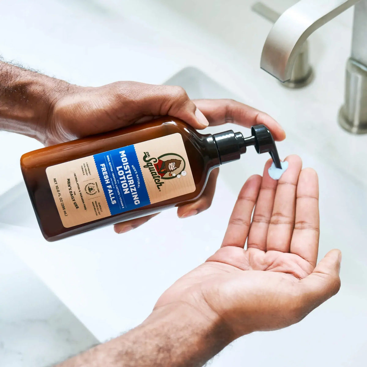 Moisturizing lotion dispenser with black pump applying product into open hands