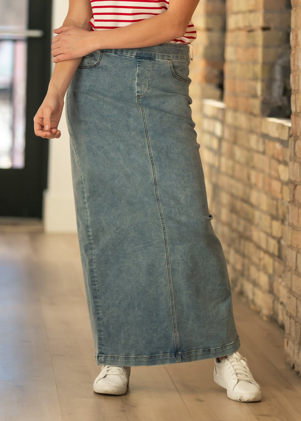 Front view of light-wash denim maxi skirt with center seam and straight hem