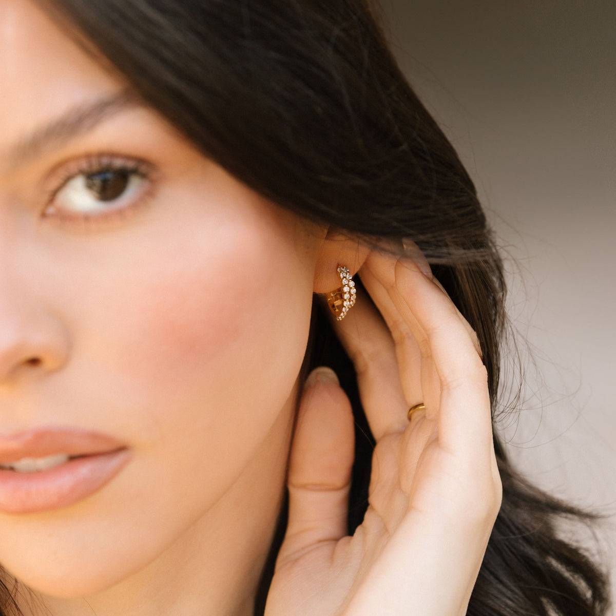 Double pave hoop earrings in gold tone on a woman's ear