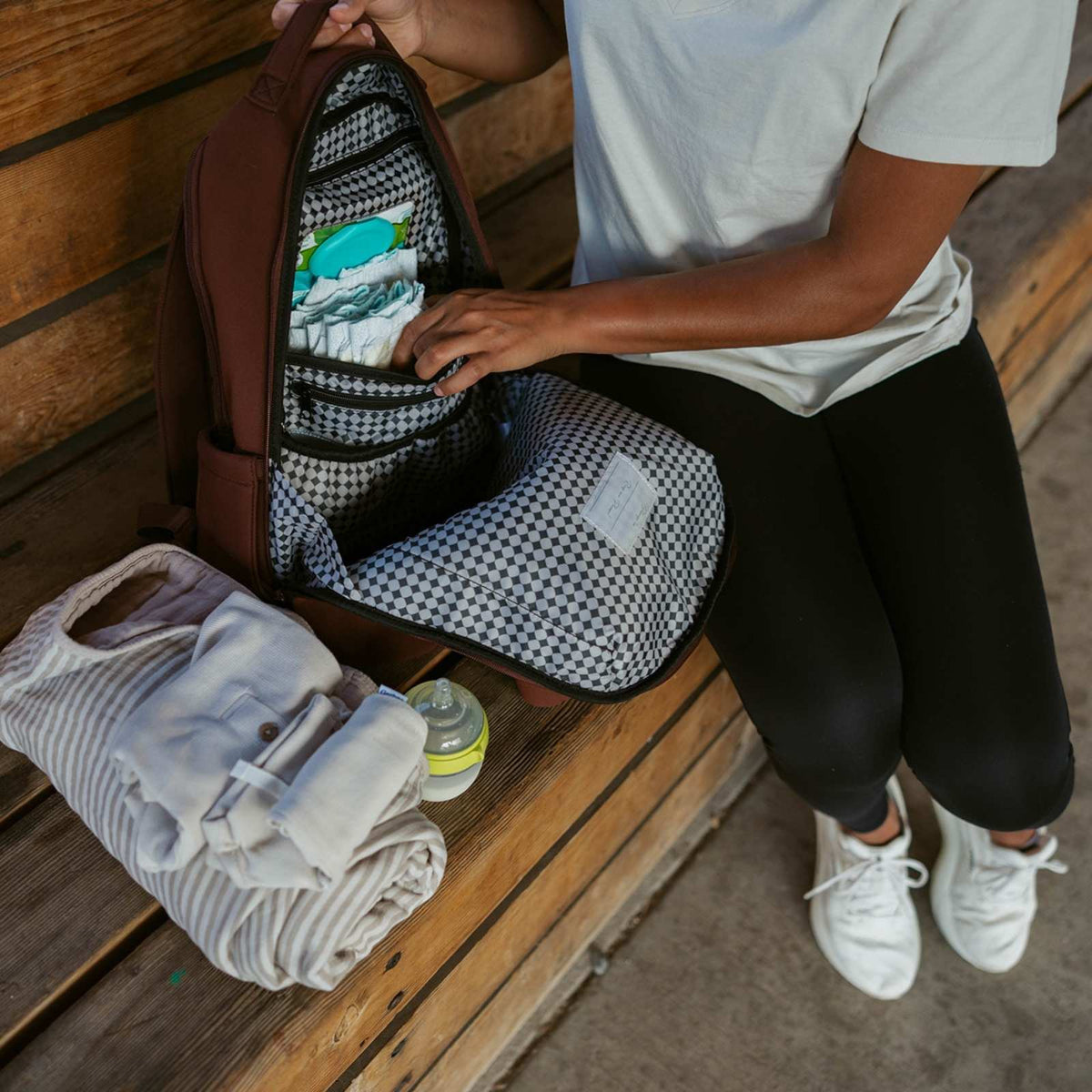 Maroon diaper backpack open with patterned interior organizer and baby items