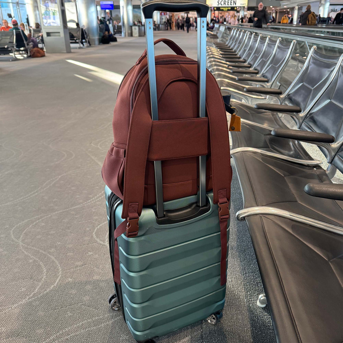 Wine-brown diaper backpack clipped to a stroller with front panel straps