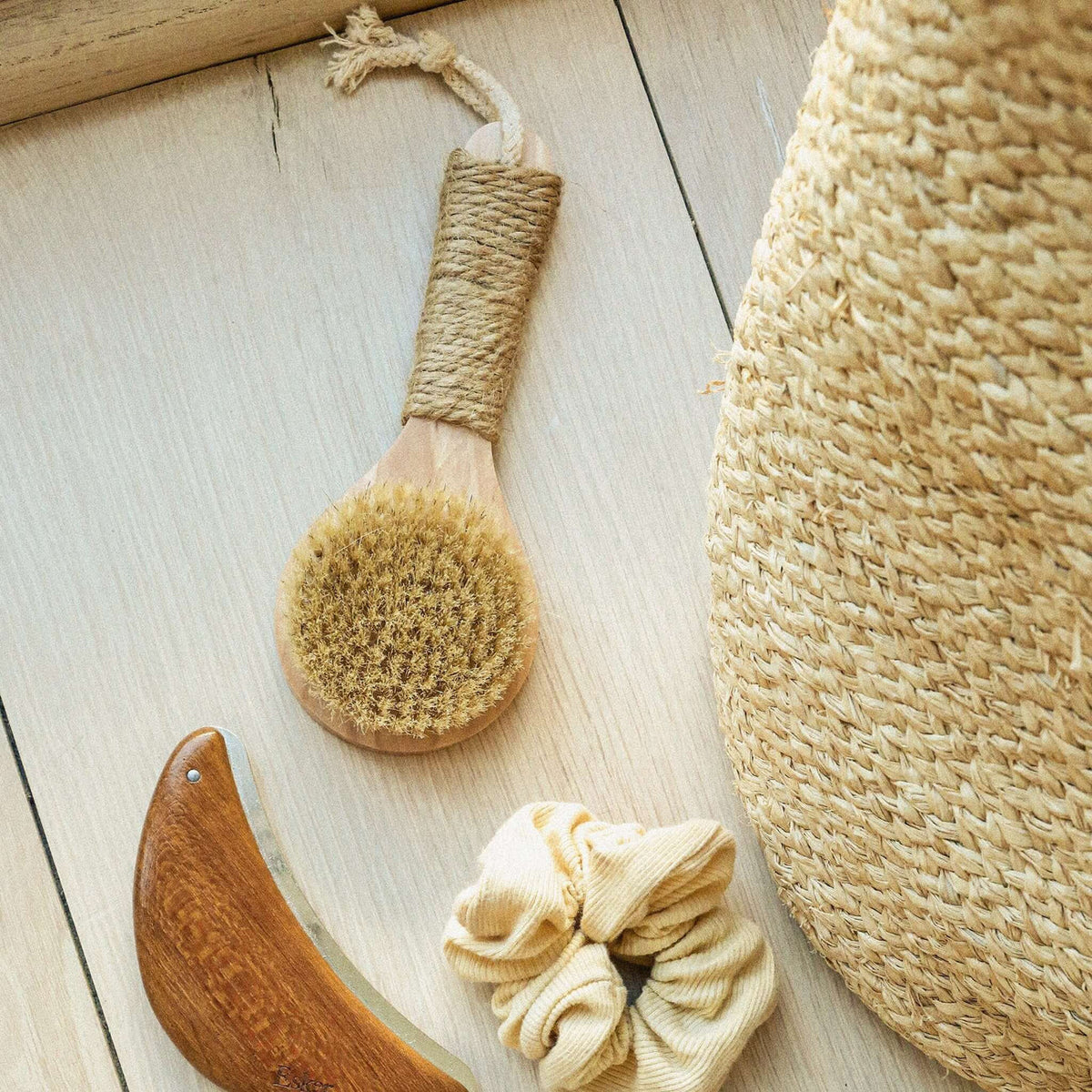 Natural bristle dry brush with hemp twine handle loop on light wood
